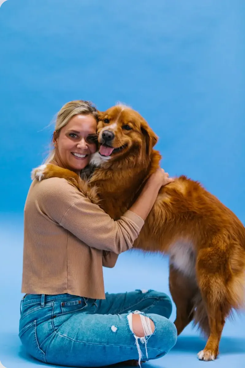 Dog owner hugging a golden retriever